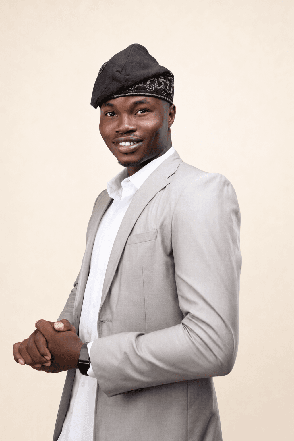 Shola Japheth in a grey suit and black fìlà cap